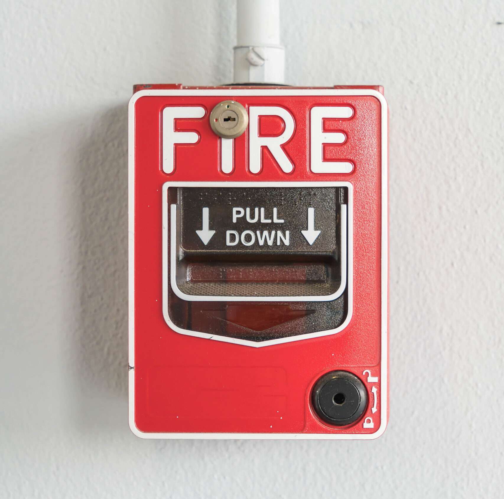 Fire alarm switch on white wall